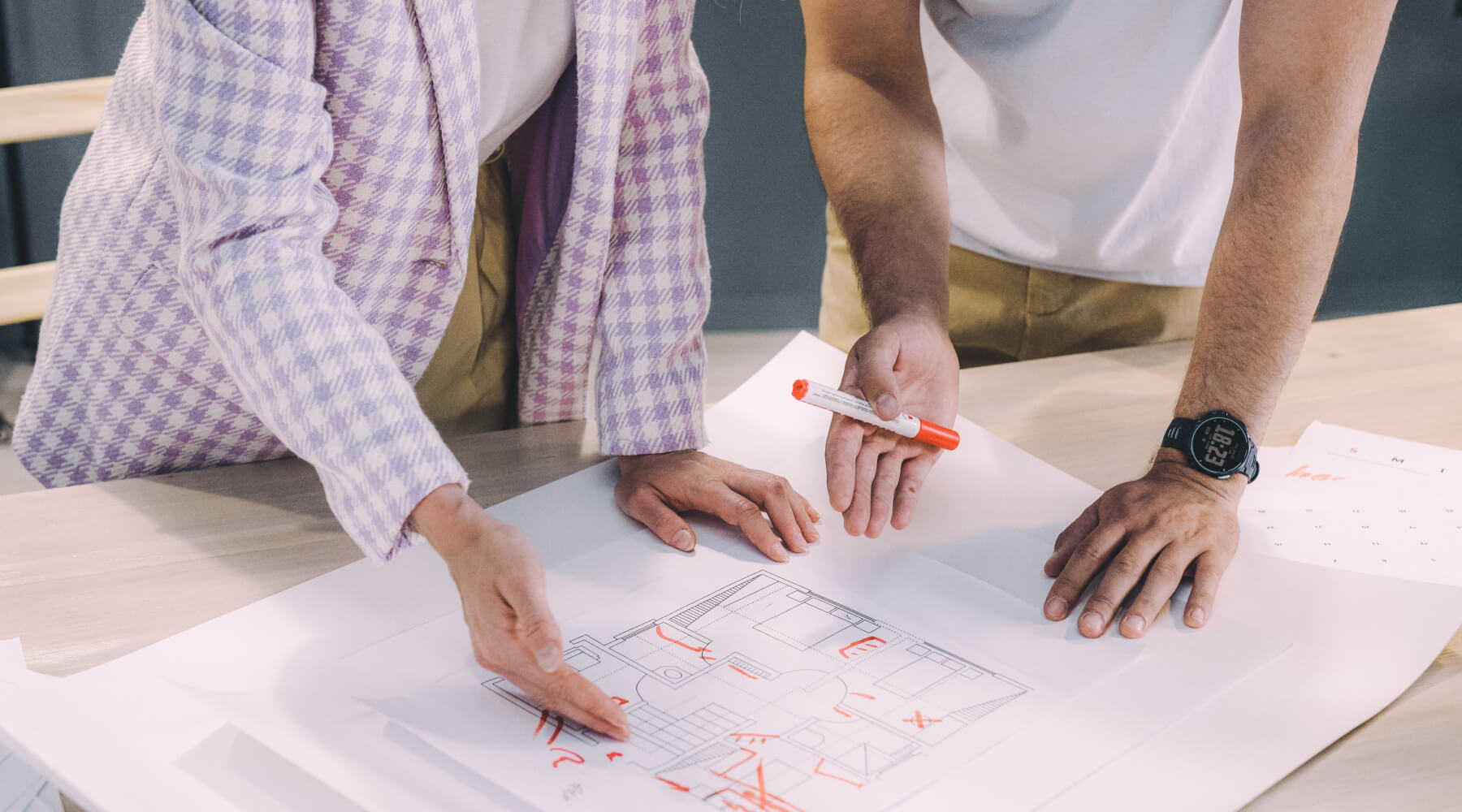 Two people reviewing and marking a floor plan