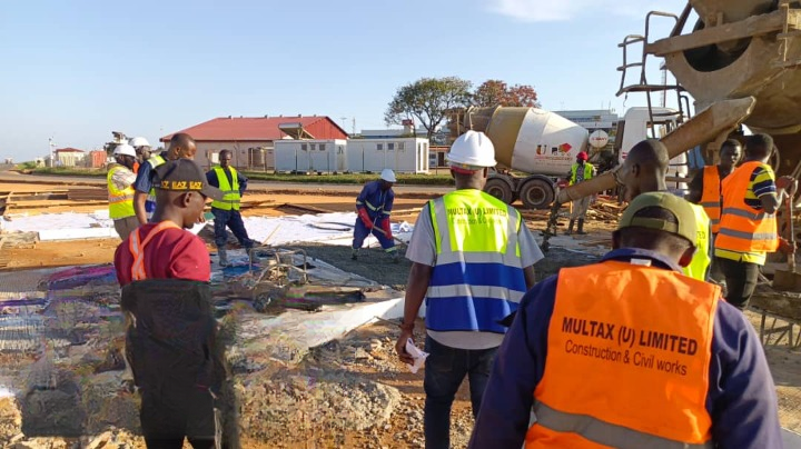 Construction crew supervising concrete placement from a mixer truck
